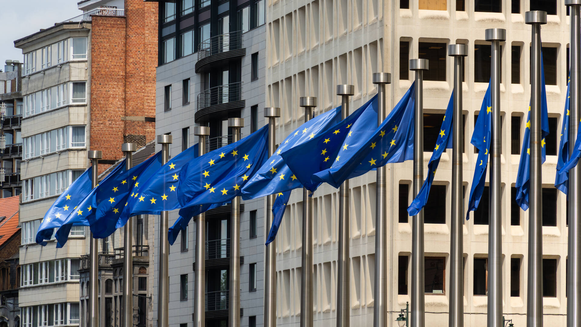 Flags of the European Union on their poles in a street of the European quarter in Brussels